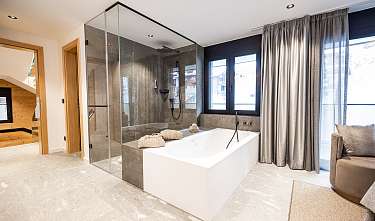 Badewanne und Dampfdusche im Schlafzimmer (links)